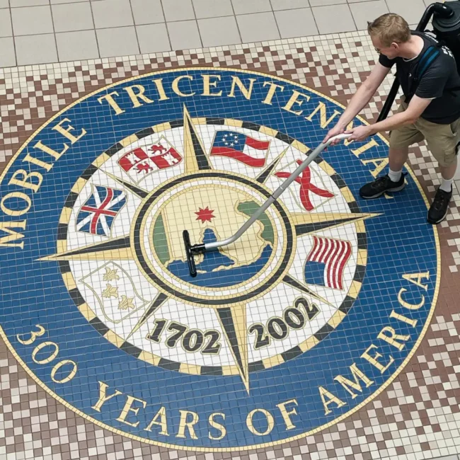 Premier Cleaning & Janitorial employee cleaning Mobile Chamber of Commerce tile floor emblem office in Mobile AL
