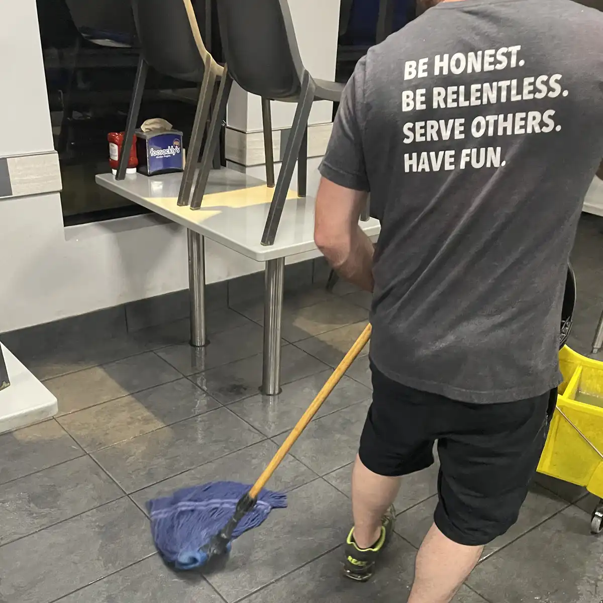 premier janitors employee mopping restaurant tile floor of foosacklys in mobile, al