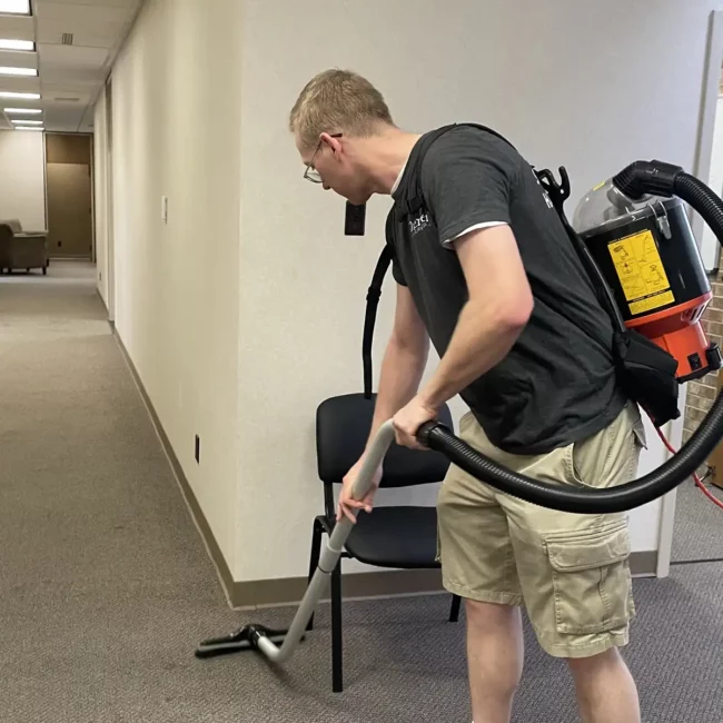 Premier Cleaning & Janitorial employee vacuuming office floor
