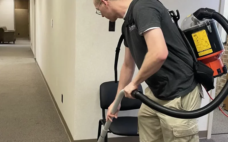 Premier Cleaning & Janitorial employee vacuuming office floor