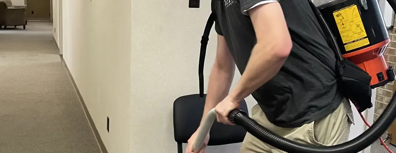 Premier Cleaning & Janitorial employee vacuuming office floor